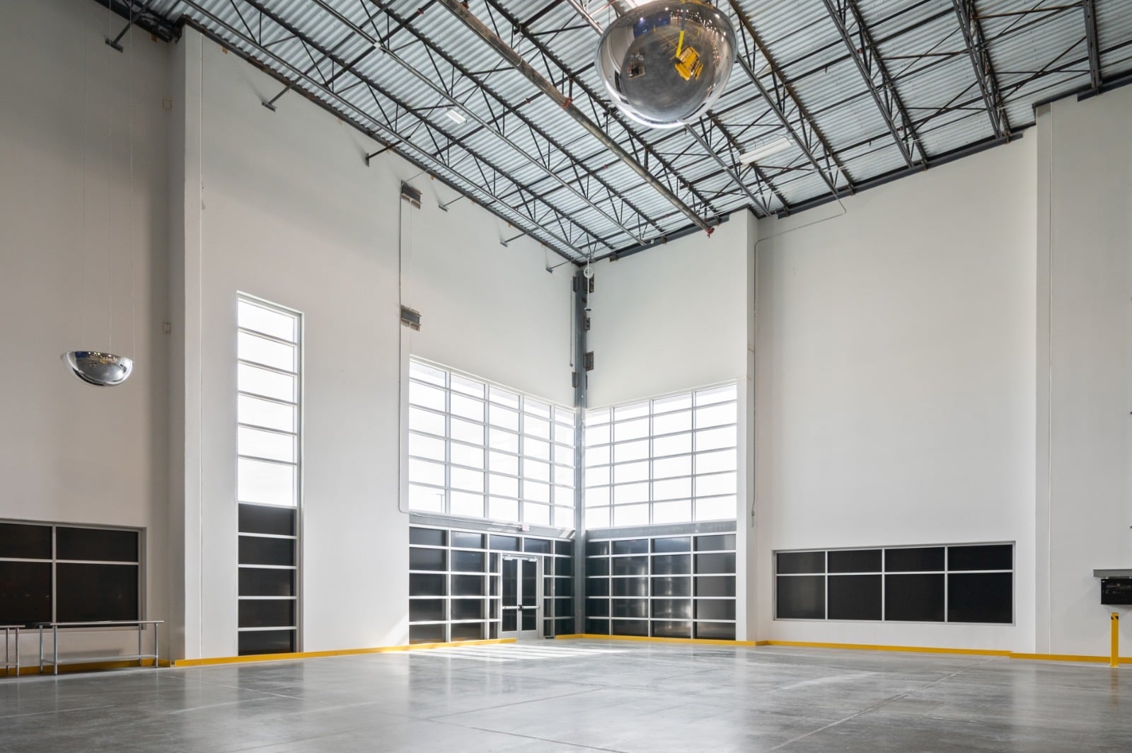 Tall painted interior bay with glazing and a yellow safety base